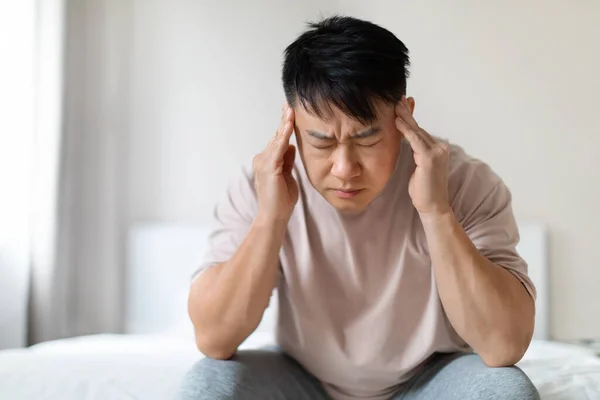 Sorglig Sjuk Medelålders Asiatisk Man Sitter Sängen Med Slutna Ögon — Stockfoto