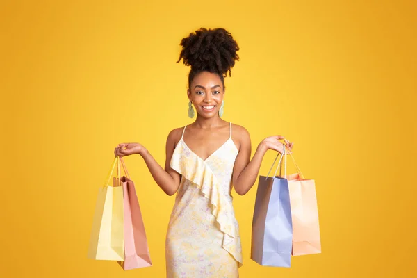 何千年ものアフリカ系アメリカ人女性のお店では 黄色の背景 スタジオに隔離された購入で多くのパッケージを示しています ショッピング 広告とオファー 支払い 購入と注文 — ストック写真