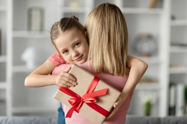 Cute Little Girl Holding Gift Box Embracing Her Mommy Loving — Stock Photo, Image