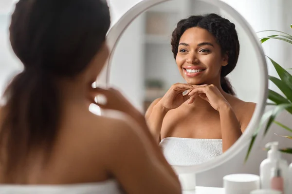 セルフケアの概念 自宅で鏡を見て美しい若いアフリカ系アメリカ人女性 魅力的な黒千年紀の女性は手でチン休憩し 彼女の反射を楽しみます 選択的なフォーカス — ストック写真