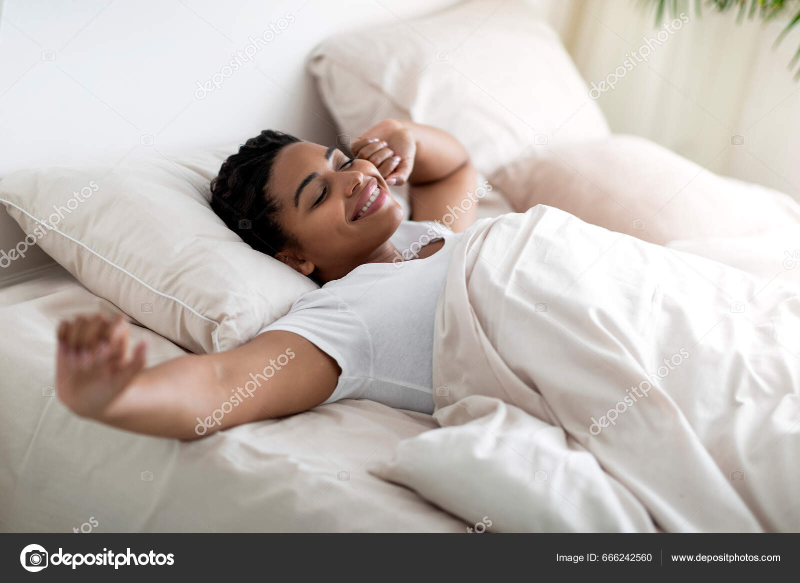 Cheerful Young African Woman Holding A Pillow And Sitting On The