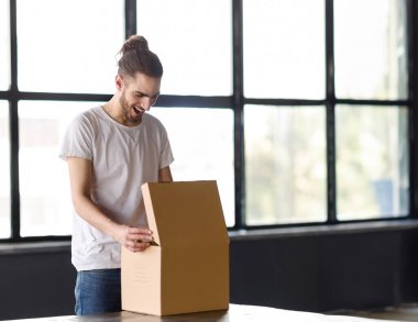 Vay canına. Heyecanlı Orta Doğulu Genç Adam Modern Ofis İçi 'nde Karton Kutu Teslimatı Yapıyor, Yazı İçin Boş Alan. Harika Teslimat Hizmeti Reklamı