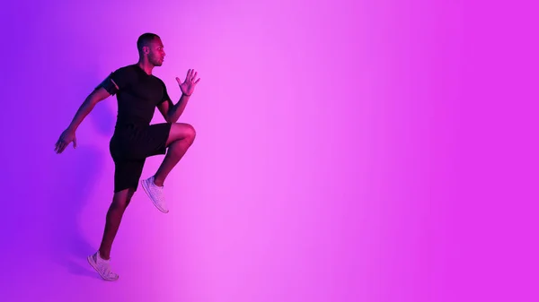 Atleta Nero Guy Jumping Esercizio Durante Allenamento Sfondo Viola Neon — Foto Stock