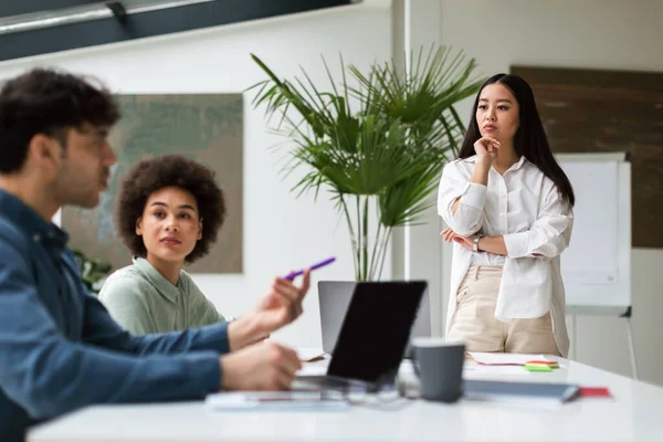 現代オフィスで働くアジア系起業家女性社員に聞く企業チームミーティングでは ビジネス上の問題を考え 解決する ビジネスウーマンへの選択的フォーカス — ストック写真