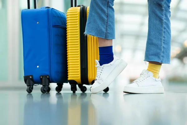 青と黄色の旅行スーツケースと飛行前に彼女の荷物で立って明るいカラフルな靴下を持つ認識できないヨーロッパの観光女性のクロップショット — ストック写真