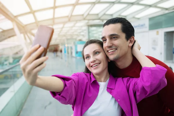 Wspomnienia Wakacyjne Szczęśliwi Turyści Małżonkowie Pozowanie Trzymając Smartfon Selfie Lotnisku — Zdjęcie stockowe
