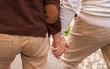 Son sınıf öğrencisi çift şehir dışında yürürken ellerin kapalı durması, arka manzara. Tanımlanamayan Olgun Adam ve Kadın 'ın Ellerinin Tutulduğu Kesilmiş Vuruşlar Hayat Boyu Aşkı simgeliyor