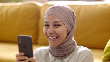 Komik online içerik. Tesettürlü genç, kaygısız Müslüman kadının portresini yakından çek. Akıllı telefonuyla video oyunları oyna. Olumlu sonuçlarının tadını çıkar.