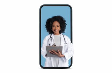 Beyaz önlüklü mutlu siyah kadın terapist beyaz stüdyo arka planında izole edilmiş büyük akıllı telefon ekranına notlar alıyor. Tıbbi blog, sağlık uygulaması, uzaktan hizmet
