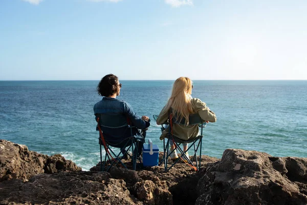 Young Man Woman Relaxing Camping Chairs Beach Rocks Ocean Millennial — 스톡 사진