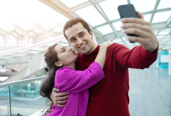 Amusant Aéroport Joyeux Jeune Femme Embrassant Son Mari Faisant Selfie — Photo