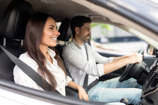 stock image Car renting, leasing, buying. Cheerful positive loving millennial couple test drive new auto together, shot from side window. Happy man and woman have car trip in summer. Vacation, recreation
