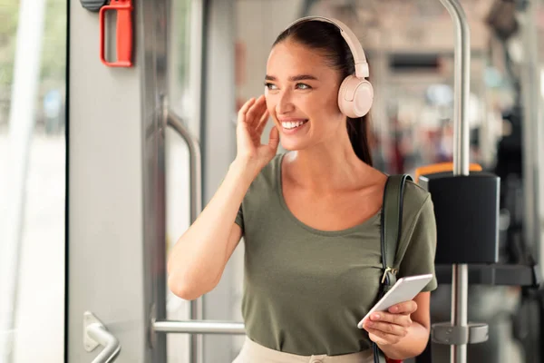 Mujer Pasajera Sonriente Sosteniendo Teléfono Móvil Usando Auriculares Tranvía Disfrutando — Foto de Stock