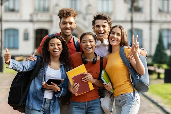 学生生活 幸せな大学の友人の肖像一緒にキャンパスで屋外でポーズ バックパックとワークブックと陽気な若い多民族男性と女性のグループは カメラで微笑む — ストック写真