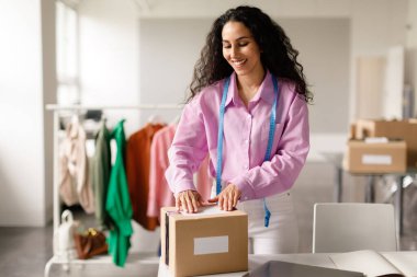 Modern Showroom Interior 'da çalışan Mutlu Dressmaker Kadın Giysi Siparişiyle Paket Paketi, Moda Tasarımı Keyifli Paketleme Süreci. Küçük Giysiler Perakende, Ticaret