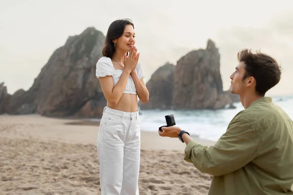 沿岸の提案 海岸線の海のビーチで幸せな女性に提案婚約指輪を持つロマンチックな若い男は フリースペース つま先の間の砂 空気中の愛 — ストック写真