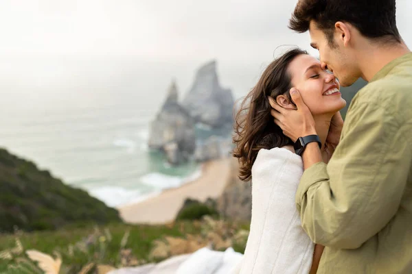 海洋魔法だ 海の海岸線で美しい景色を持つ岩の上にデートを持っているカップルを愛し 男は女性にキス 柔らかい瞬間を楽しんで スペースをコピー — ストック写真