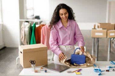 Küçük moda işi ve perakende satış. Tasarımcı kadın kendi butiğinde duran kutuda teslimat için bavul hazırlıyor. Satış Asistanı Çanta Satma Aksesuarları İnternette Giysi Satış Odası