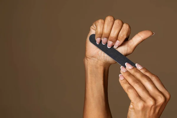 Afroamerykanka Średnim Wieku Manicure Trzymając Pilnik Paznokci Izolowane Brązowym Tle — Zdjęcie stockowe