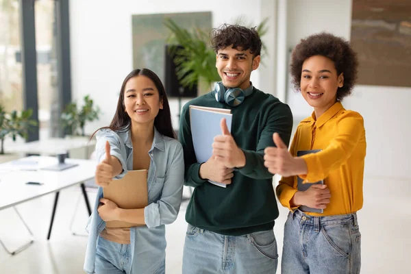 Happy Diverse Students Smiling Gesturing Thumbs Camera Standing Coworking Space — Stock Photo, Image