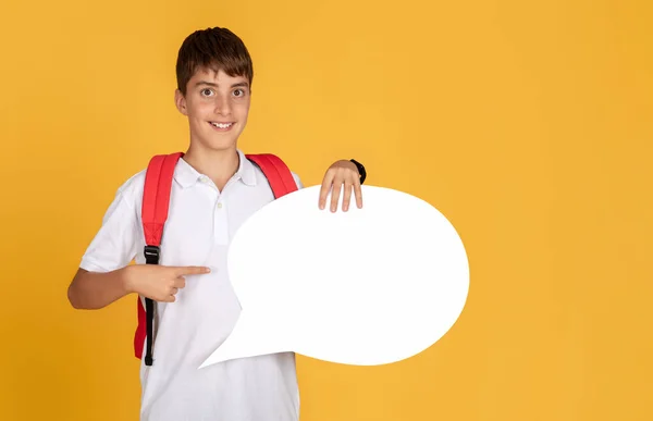 快乐的欧洲小学生 背着背包 手指指向抽象的云雾 寻找单词和思想 孤立在黄色的工作室背景下 建议研究 学校教育 广告和提供 — 图库照片