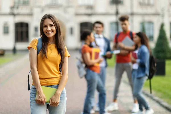 Öğrenci Hayatı Kampüste Üniversite Arkadaşlarının Önünde Poz Veren Gülümseyen Genç — Stok fotoğraf