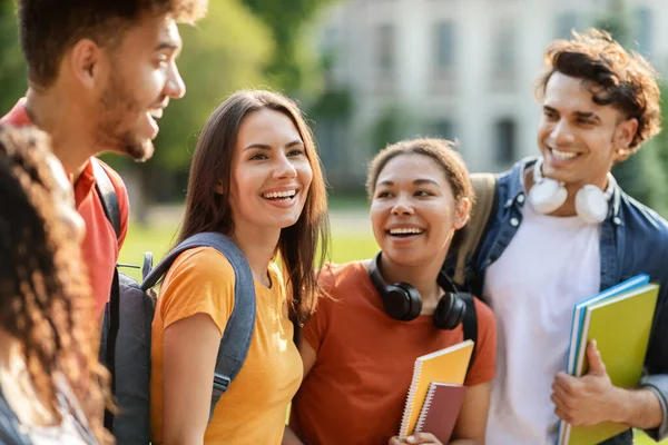 美しい女性学生ウォーキング カレッジの友達とアウトドア 若い多民族のグループチャットと一緒に笑いながらクラスに行く 楽しいキャンパスライフ 閉じるショット — ストック写真