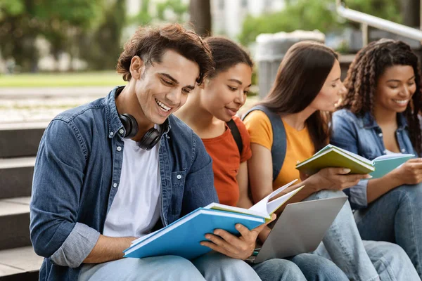 外で一緒に試験のために準備する多民族学生のグループ ラップトップやワークブックを使用して キャンパス外で勉強若い大学の友人の笑顔 近代教育を楽しんで クローズアップ — ストック写真