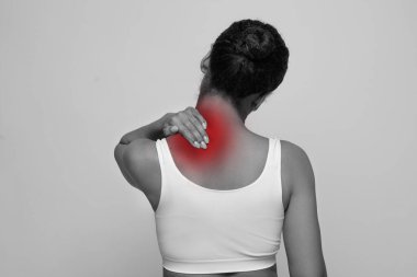Afro-beyaz bir Afro-Amerikan bayanın kırmızı boynu ovaladığı sabah uyandıktan sonra kas sıkışması, stüdyo arka planı, fotokopi odası. Zihinsel stres, osteoartrit, omurilik stenozu.