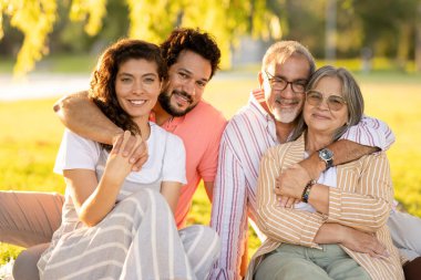Gülümseyen Avrupalı yetişkin ve yaşlı çift sarılıyor, tatilin tadını çıkarıyor, yaz tatilinde, dışarıda, parkta birlikte haftasonu geçiriyorlar. Aşk, aile ilişkisi, randevu, yürüyüş ve tatilde yaşam tarzı