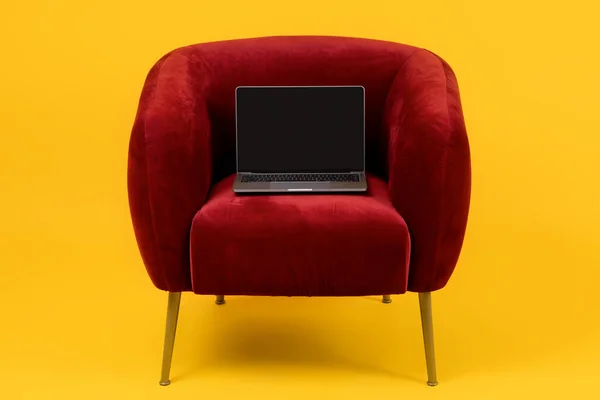 具有空屏幕的笔记本电脑 用于在线网站广告的调校 站在黄色背景的红色扶手椅上 便携式个人电脑的工作室镜头 自由与互联网技术 — 图库照片