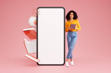 E-Öğrenme Uygulaması ve Web Sitesi. Pembe Arkaplan 'da boş Dokunmatik Ekranlı Büyük Cep Telefonu' nun yanında dijital tablet kullanan Arap genç kadın. Mockup, Eğitim Simgeleri Kolajı, Tam Uzunluk