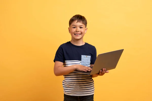 Dizüstü Bilgisayarı Tutan Bilgisayarında Yazan Gülümseyen Sarı Arka Planda Izole — Stok fotoğraf