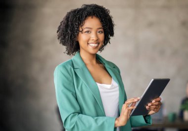 İş Başvurusu. Modern Ofisteki Gri Duvar 'ın Üzerinde Kokan Tablet Kullanan Neşeli Siyah İş Kadını Portresi. Girişimci Kadın İş Yerindeki Dijital Bilgisayarla Web Sörfü