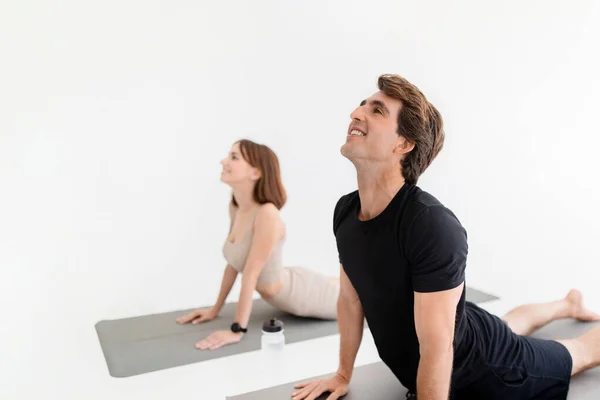 笑着的年轻的高加索女人和穿着运动服的男人喜欢一起锻炼 练习瑜伽 在健身房或室内伸展身体 家庭体育生活方式 医疗保健 — 图库照片