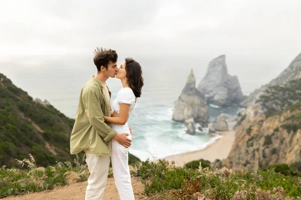 若い慎重な愛するカップルが抱擁し キスし 海岸近くの岩の上の海岸線で結合し 男と女性は一緒に時間を楽しんで サイドビュー 無料スペース — ストック写真