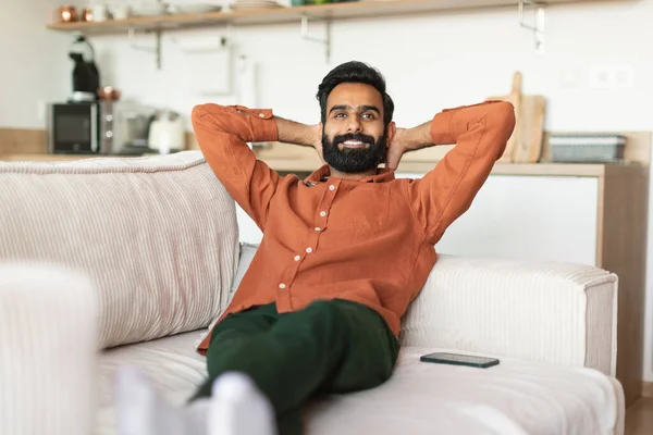 印度男人放松了 可以随意地享受家里的舒适 坐在那里 手牵着手放松地望着别处 周末休息 在家里玩得很开心的人 — 图库照片
