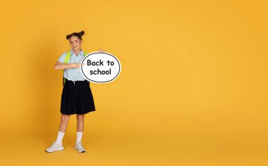 Kafkasyalı genç kız soyut bulut gösteriyor ve okula geri dönüyor. Turuncu stüdyo arka planında izole edilmiş. Bilgi, öğrenim, eğitim tavsiyesi, reklam ve teklif