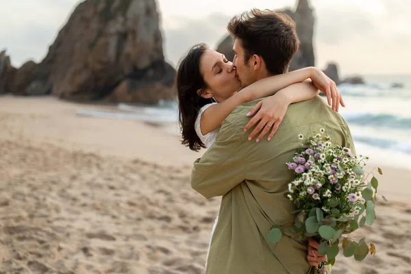 Młodzi Europejscy Małżonkowie Zakochani Romantycznej Randce Plaży Mężczyzna Trzymający Kwiaty — Zdjęcie stockowe