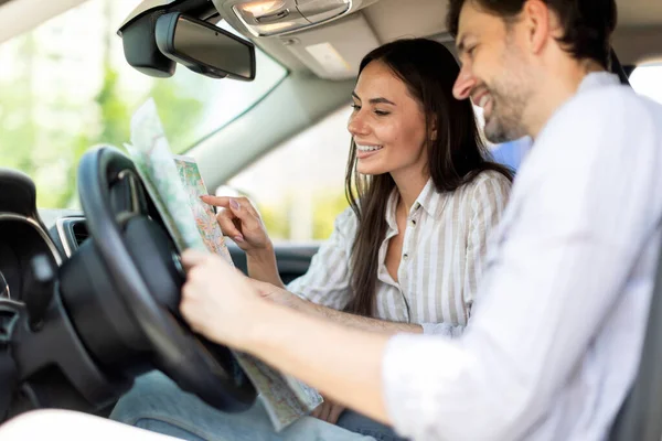 ポジティブなミレニアル世代のカップルは 車で一緒に旅行しています オートフロントの座席に座り 地図を確認し 運命を選択して旅行する陽気な若者と女性 サマーホリデー — ストック写真