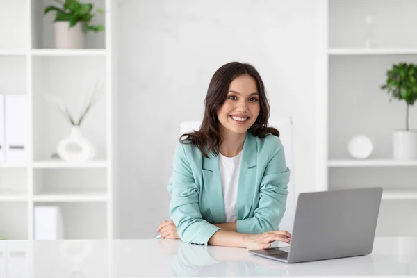 与计算机配套的快乐的年轻的高加索女商人喜欢在办公室内部从事专业工作 商业和工作 视频通话 官方生活方式和广告 — 图库照片