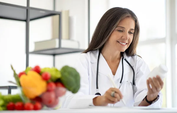 Positieve Europese Volwassen Vrouwelijke Arts Voedingsdeskundige Maakt Notities Dieet Programma — Stockfoto