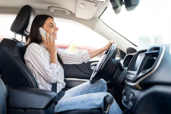 자동차를 운전하는 전화로 말하는 캐주얼 드라이버를 착용하는 행복한 매력적인 스티어링 — 스톡 사진
