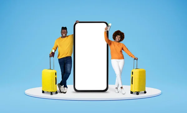 千年佳节快乐的黑人夫妇一起去度假 站在讲台上 拿着白色的空屏幕 拿着护照 蓝色背景的手机 — 图库照片