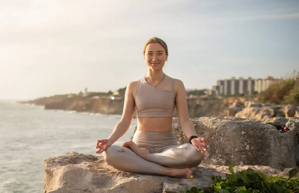 积极的千年期高加索女运动员穿着运动服 以莲花的姿势练习瑜伽 享受休息 在海滩锻炼 室外和平 身体护理和生活方式 — 图库照片