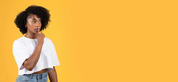 严肃的年轻黑人卷曲女士穿着白色T恤 用手做着害羞的手势 与橙色背景隔离 工作室 生活方式 广告和提供 好消息 — 图库照片