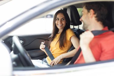 Seyahatin tadını çıkarın. Heyecanlı genç çift ön koltuklarda oturuyor ve birbirlerine gülümsüyorlar. Yakışıklı sakallı adam araba kullanıyor. Güzel kız arkadaşını veya karısını tatile götürüyor.