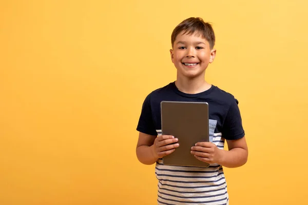 Çocuklarda Gadget Bağımlılığı Sarı Arka Planda Dijital Tablet Tutan Mutlu — Stok fotoğraf