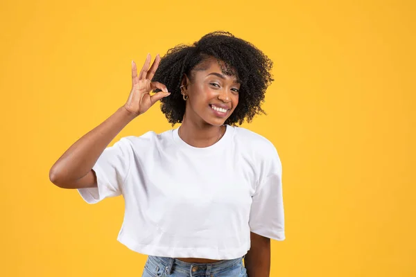 快乐的年轻黑人卷曲女士 身穿白色T恤 手握手签 隔离在橙色背景下 工作室 认可的姿态 生活方式 广告和提供 人类的情感 好消息 — 图库照片
