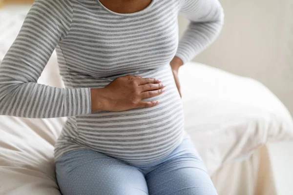 Czarna Kobieta Ciąży Ostrym Bólu Dotykająca Pleców Brzucha Podczas Siedzenia — Zdjęcie stockowe